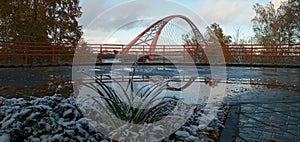 Red arch of the cable-stayed suspension bridge over the wide Ob River. Novosibirsk, Russia.