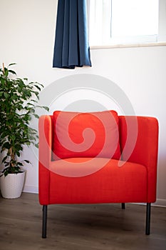 Red armchair in a home under a window