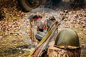 Red Army weapons and helmet against the campfire background