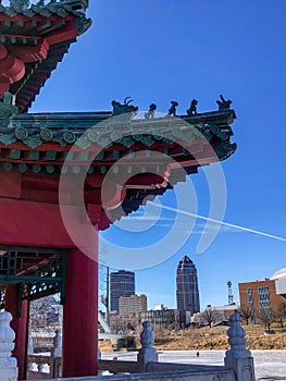 Red Asian pavilion by Des Moines, Iowa skyline