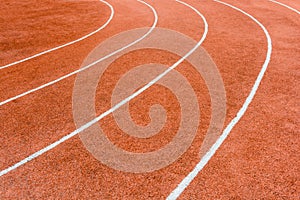 A red athletics track with white lines delimiting the lanes