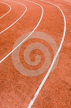 A red athletics track with white lines delimiting the lanes