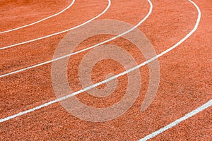 A red athletics track with white lines delimiting the lanes