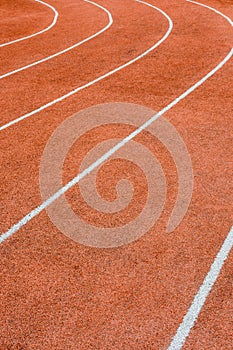 A red athletics track with white lines delimiting the lanes