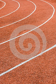 A red athletics track with white lines delimiting the lanes