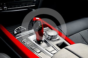 Red automatic gear stick of a modern car, car interior details. Automatic transmission
