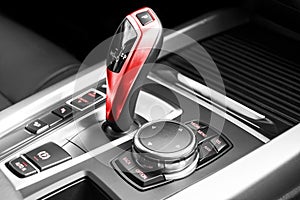 Red Automatic gear stick of a modern car, car interior details. Black and white.