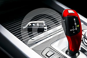 Red automatic gear stick of a modern car, car interior details. Wireless car key.