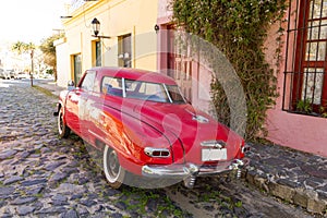 Red automobile on one of the cobblestone streets, in the city of Colonia del Sacramento, Uruguay. It is one of the oldest cities