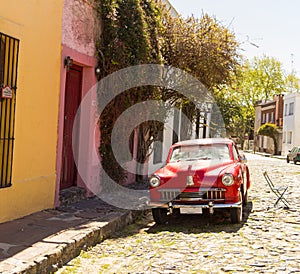 Red automobile on one of the cobblestone streets, in the city of Colonia del Sacramento, Uruguay. It is one of the oldest cities