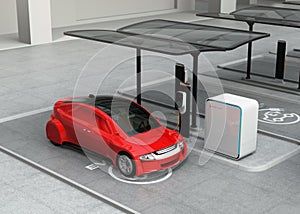 Red autonomous car in electric vehicle charging station