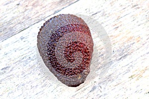 Red avocado on a background of pure ancient wood