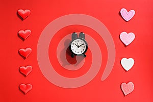 A red background with a clock, concept of the passage of time in love, surrounded by hearts