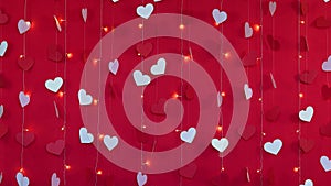 Red background with white hearts and flashing garland lamps. Valentines day concept