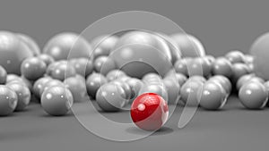 Red ball in focus with bunch of white balls behind it - red one stands out