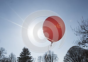 Red balloon and blue sky background with sun