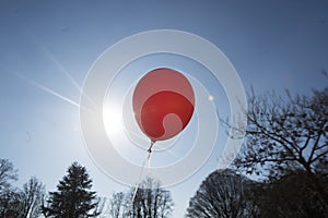 Red balloon and blue sky background with sun