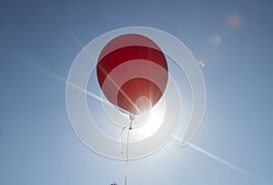 Red balloon and blue sky background with sun