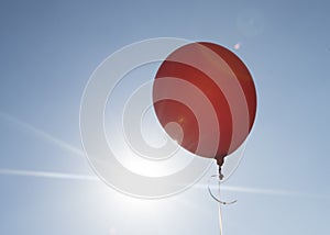 Red balloon and blue sky background with sun