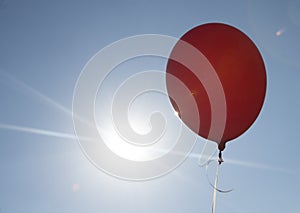 Red balloon and blue sky background with sun