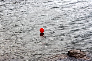 Red balloon in the grey water