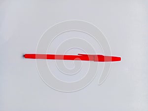 Red ballpoint pen on white background. One red pen for writing.