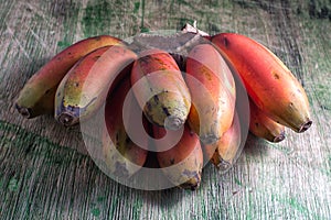 Red banana bunch on wood surface