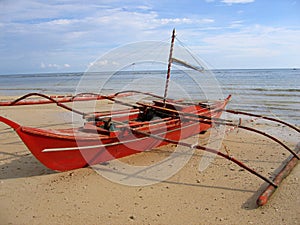 Red banca outrigger fishing boat philippines