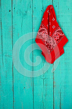 Red bandana hanging on blank antique teal blue wood door