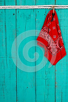 Red bandana and key hanging by rope on antique teal blue background