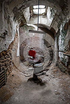 Red barber chair in a jail cell