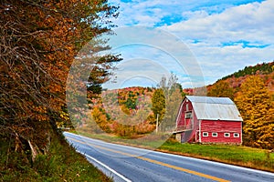 Red barn alongside Vermont roads in peak fall