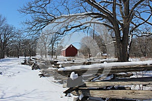 Red Barn behind Split Rail Zig Zag Fence in Winter