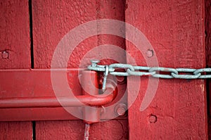 Red barn door with metal chain and lock