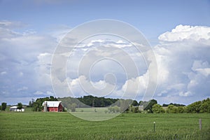 Red barn and field below dramatic cloudscape