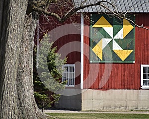 Red Barn with Green Gold and White Quilt