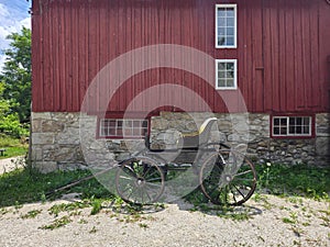 Red Barn with Historic Horse Carriage in Rural Setting