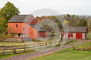 Red barn and log cabin on dirt road at historic Daniel Boone Homestead