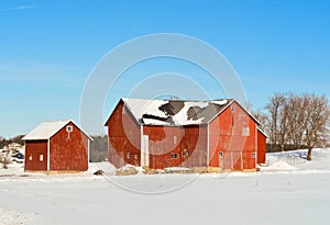 Red Barn and Outbuildings in Winter Countryside with Snow