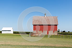 Red barn in rural Iowa on a cloudless summer day.