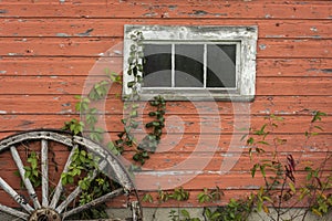Red barn white window and wagon wheel