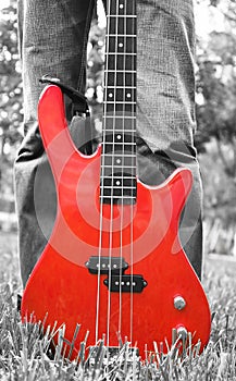 Red bass guitar on the grass