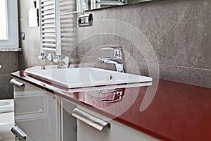 Red bathroom faucet reflection photo