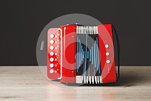 Red bayan toy accordion on gray background