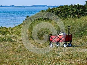 Red beach cart trolley by the sea shore