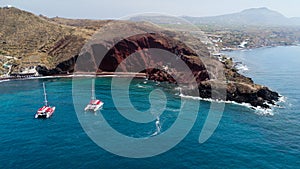 Red beach with catamarans in Santorini, Greece photo