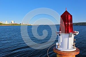 A red beacon light on a cement platform in the Strait of Canso near Port Hawkesbury Nova Scotia