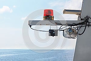 Red beacon light on white mast ship