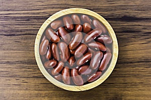 red beans or kidney bean in wooden bowl isolated on wood table background.