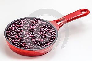 The red beans are in the red pan on the white background photo